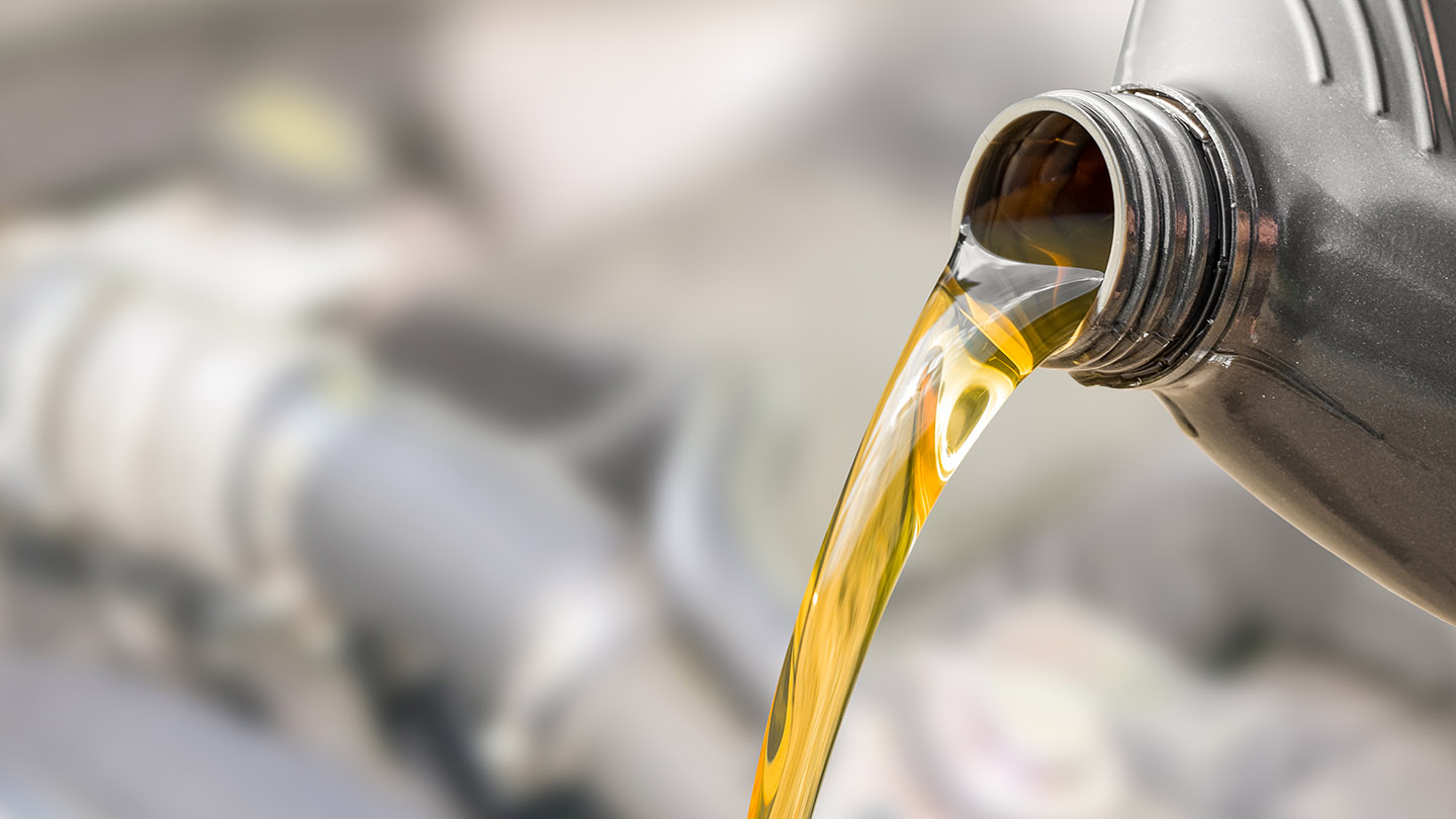 Pouring oil to car engine. Fresh oil poured during an oil change to a car. Pouring oil to car engine. Fresh oil poured during an oil change to a car.